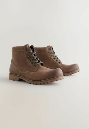 Bruine leren enkelboots met ronde neuzen, grijze veters en een gedetailleerde rubberen zool. Heeft contrasterende stiksels en een robuuste uitstraling.