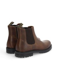 Braune Leder Chelsea-Boots mit elastischen seitlichen Einsätzen und strukturierten Gummisohlen, ausgestattet mit Zuglaschen für ein einfaches Anziehen.