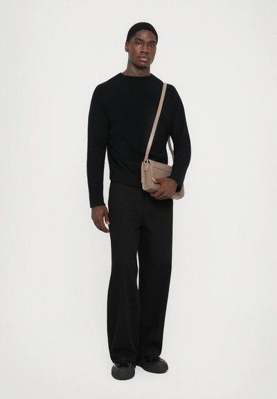 Black knitted sweater, wide black pants, and black shoes. Gray crossbody bag with a textured finish. Simple, modern design.