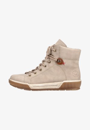 Beige leren enkellaarsjes met metalen oogjes, gestructureerde veters, rubberen zool, contrasterende bruine accenten en gestikte details aan de zijkanten.
