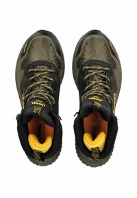 Zapatillas de deporte en verde oliva y negro con una parte superior texturizada, detalles en amarillo, cordones negros y una suela robusta para mayor tracción.