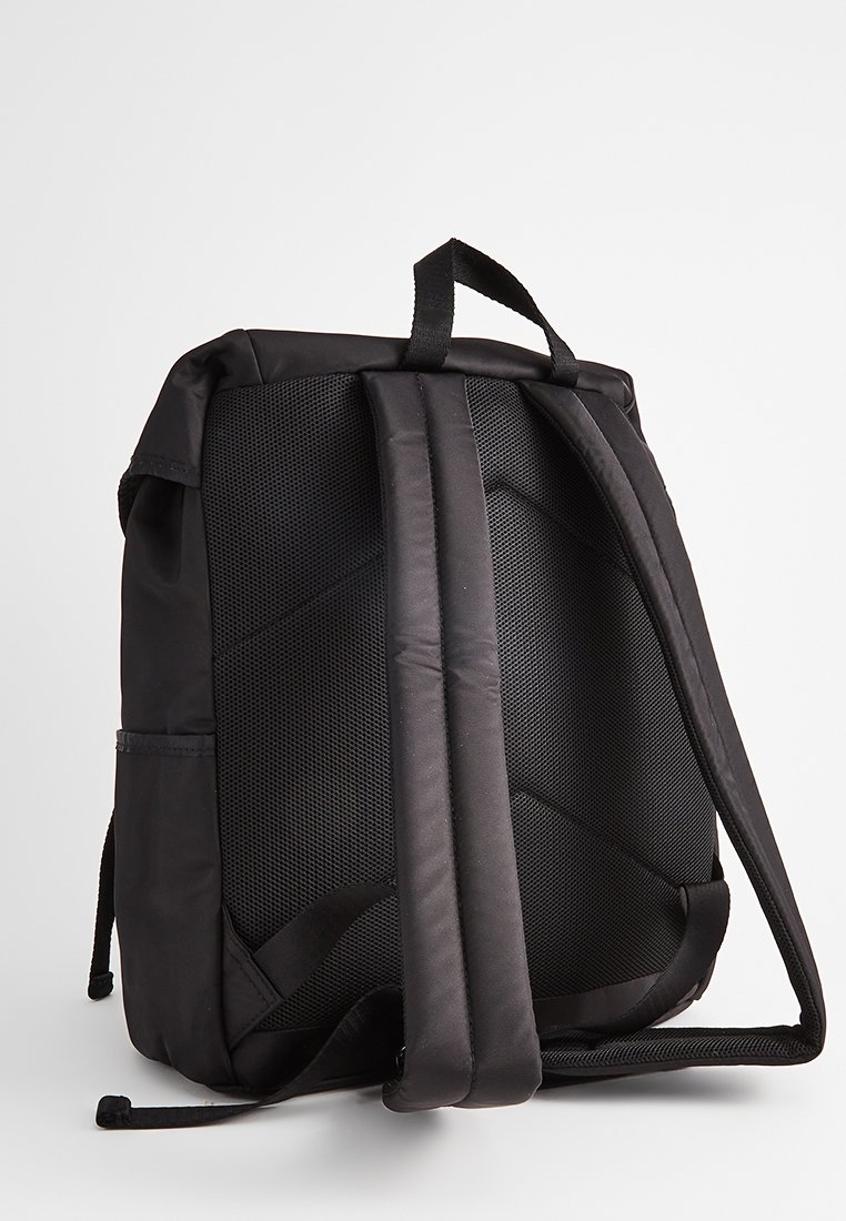 Czarny plecak z teksturowanym siatkowym tyłem, wyściełanymi szelkami i górnym uchwytem. Charakteryzuje się prostym, funkcjonalnym designem.