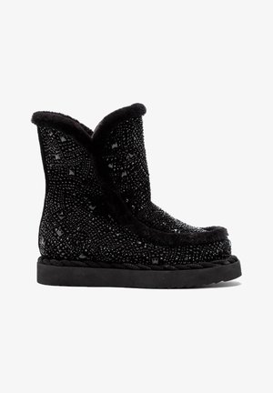 Bottes d'hiver noires mi-mollet avec une semelle texturée, décorées de petits clous noirs et bordées de fourrure noire douce le long du haut et de la couture avant.