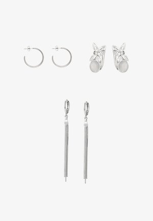 Kolme paria hopeisia korvakoruja: tavalliset renkaat, lehden ja kiven muotoiset napit sekä pitkät ketjutupsukorvakorut valkoisella taustalla.