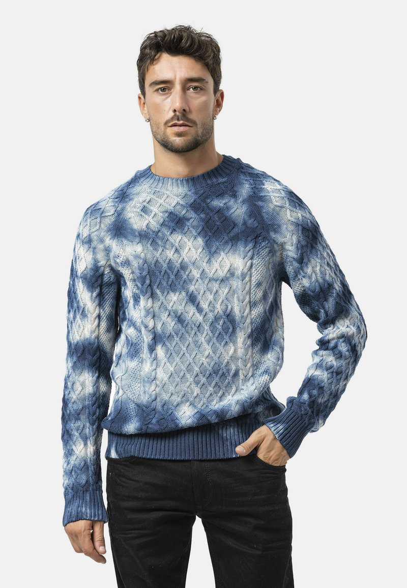 Blauwe gebreide trui met ruitpatroon, met een mix van lichtblauwe en donkerblauwe tinten, geribbelde hals en mouwen, textuurstof.