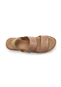 Tan leather sandal featuring wide straps and a cushioned footbed. White stitching detail adds subtle design contrast. Flat sole.