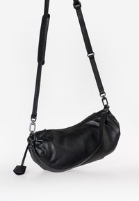 Schwarze Leder-Umhängetasche, schlanke zylindrische Form, strukturierte Oberfläche, verstellbarer Tragegurt, Reißverschlussverschluss und metallische Hardware-Akzente.