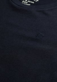 Marineblauw katoenen T-shirt met een ronde hals, voorzien van een geborduurd logodetail. Gladde textuur, minimalistisch ontwerp, geen patronen.