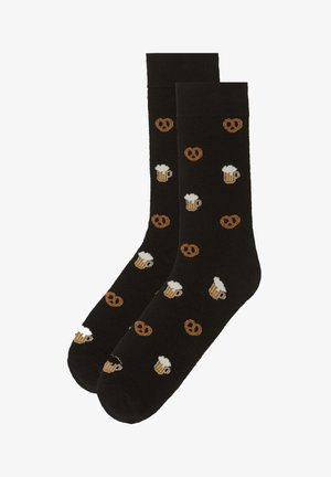 Schwarze Socken mit einem wiederholten Muster von Bierkrügen und Brezeln in Braun und Creme. Hergestellt aus weichem, dehnbarem Strickmaterial.