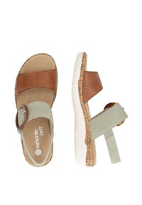 Brown and green sandals with leather straps, cork soles, and a white platform; features a circular buckle detail on the green strap.