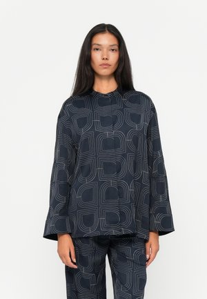 Marineblå topp med hvitt geometrisk mønster, med rund hals og vide ermer. Laget av mykt stoff. Kombinert med matchende underdeler.