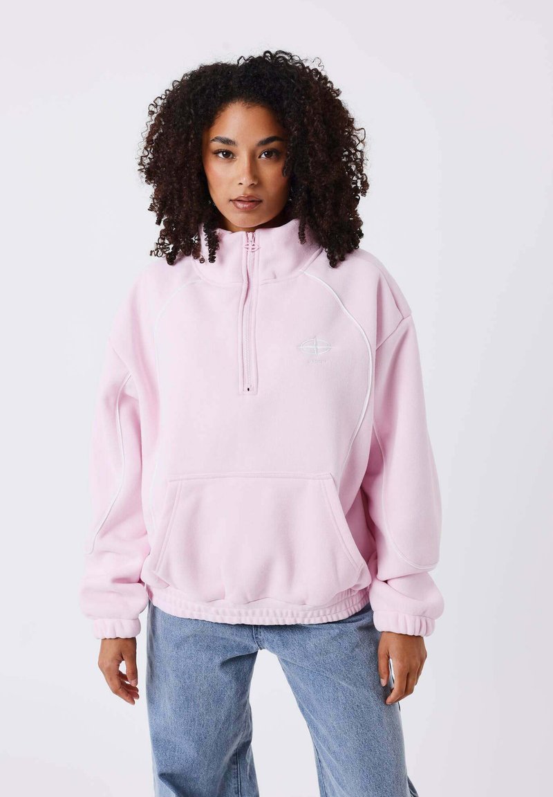 Lichtroze sweatshirt met hoge kraag, half-ritssluiting en voorzak. Heeft witte accenten en een ontspannen pasvorm met elastische manchetten.