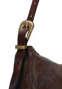 Cinghia di una borsa in pelle marrone con una superficie testurizzata, dotata di una fibbia in metallo dorato e un design regolabile con più fori.