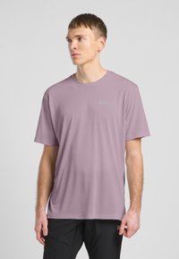 T-shirt corto a maniche corte di colore lavanda chiaro con scollo rotondo e dettaglio logo sul lato sinistro del petto. Tessuto morbido e vestibilità rilassata.