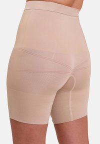 Hoge taille shapewear shorts in een Nude kleur, gemaakt van rekbare stof met een gladde textuur en naadloos ontwerp. Heeft een tweede huid pasvorm.
