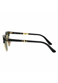 Occhiali da sole neri con accenti dorati, dotati di un design con cima piatta e naselli trasparenti. Le astine sono eleganti con una leggera curva.