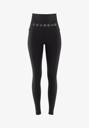 Černé legíny s vysokým pasem a hladkým povrchem, které mají řadu 8 bílých symbolů podél horního pásku. Elastický a obepínající design.