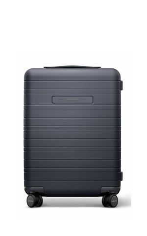 Dark gray hard-shell suitcase with horizontal ridges, a top handle, and four 360-degree spinner wheels at the base.