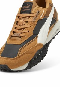 Sneaker in suede marrone e tessuto nero con accenti bianchi, suola intermedia testurizzata, chiusura con lacci e suola in gomma con impugnature circolari.