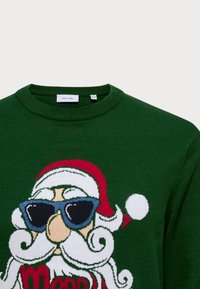 Grüner Strickpullover mit einem Santa-Design, der eine Sonnenbrille, einen roten Hut und den weißen Schriftzug "Merry" trägt. Weicher Stoff, runder Kragen.