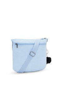 Borsa a tracolla azzurra chiara con texture liscia, chiusura a zip, tracolla regolabile e un accento di pompon nero. Design compatto e pratico.