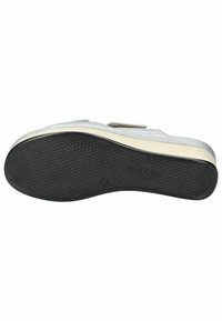 Zapato gris sin cordones con parte superior texturizada, mostrando una suela de goma negra con pequeños puntos elevados para tracción. Borde grueso y acolchado.