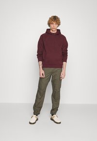 Carhartt WIP HOODED CHASE - Jersey con capucha - amarone/gold
