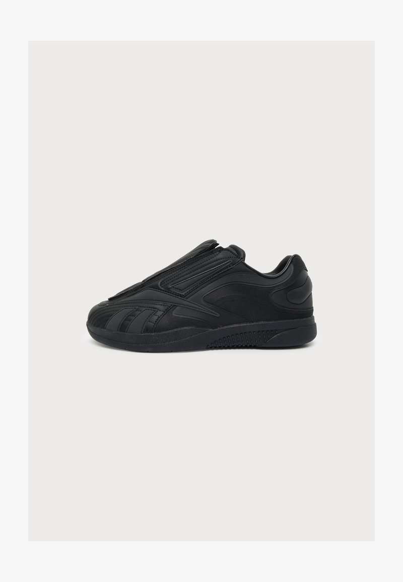 Μαύρο αθλητικό sneaker με κομψό σχεδιασμό, υφασμένο πέλμα, και στυλ slip-on χωρίς ορατά κορδόνια, εμφανίζεται από το πλάι σε λευκό φόντο.