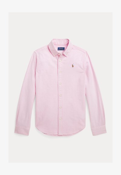 Gaiši rozā pogājamā krekla ar garām piedurknēm, apkakli un mazu izšūtu logotipu uz krūts. Audumam ir gluda tekstūra.