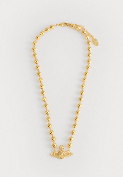 Collier en perles dorées avec un pendentif central présentant des détails complexes et des accents en pierre, mettant en valeur une finition lisse et brillante.