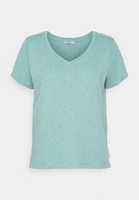 Tričko s výstřihem do V v světle modré barvě, vyrobené z jemné, texturované tkaniny. Krátké rukávy a uvolněný střih s cedulkou po straně.