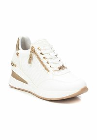 Zapatillas deportivas blancas con cuña, superficie texturizada, detalles en dorado, cierre con cremallera y cordones. Diseño elegante con un ligero tacón elevado.