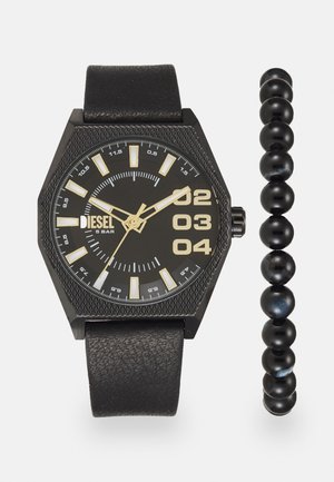 Montre octogonale noire avec des accents dorés, cadran texturé et bracelet en cuir, accompagnée d'un bracelet en perles noires avec une finition brillante.
