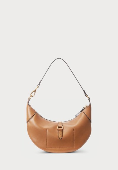 Barna bőr hobo táska ívelt formával és levehető pánttal. Elöl zseb található, arany tónusú csattal díszítve. Sima felület.
