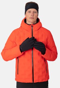Padded red jacket with a high collar and a zip front. Features two side zip pockets and black gloves. Smooth texture with a quilted pattern.