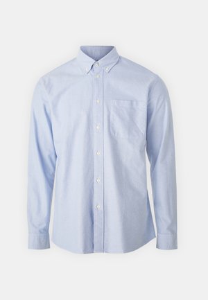 Camicia blu con bottone realizzata in tessuto leggero, dotata di colletto a punta, maniche lunghe e una tasca sul petto.