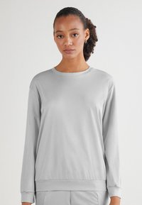 Ljusgrå långärmad sweatshirt med rundad halsringning, avslappnad passform och ribbade ärmslut och nederkant. Mjuk, slät tygtextur.