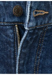 Tela de mezclilla con un tono azul oscuro, que muestra una cremallera y costuras marrones contrastantes. Presenta un detalle de botón de metal con marca y una construcción robusta.