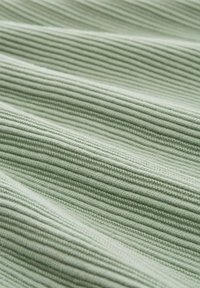 Tejido acanalado de color verde claro con una textura suave, que presenta líneas verticales espaciadas uniformemente y un sutil detalle de punto en toda su superficie.