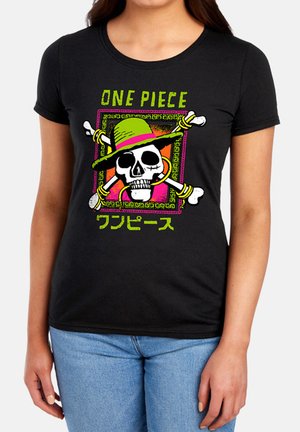 Woman wearing a black T-shirt with a colorful skull and crossbones design wearing a green hat, with "ONE PIECE" text above and Japanese text below.