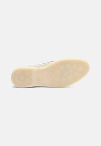 Suola della scarpa con un fondo in gomma beige testurizzato. Motivi di presa circolari e una leggera curvatura nel tallone per una maggiore trazione e flessibilità.