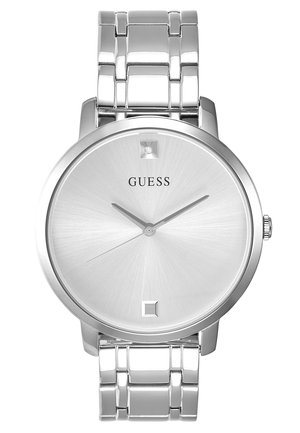 Montre-bracelet Guess argentée avec un cadran rond minimaliste, des index cristallins à 12 et 6 heures, et un bracelet métalisé à maillons.