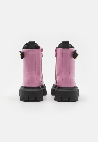 Botas de tobillo de cuero rosa con un acabado texturizado, suela negra y cremallera trasera. Incluye una lengüeta y un acento dorado en el tacón.