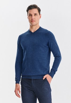 Granatowy sweter w serek z miękkiego splotu, z długim rękawem. Żebrowany dół i mankiety. Gładki design bez wzorów lub akcentów.
