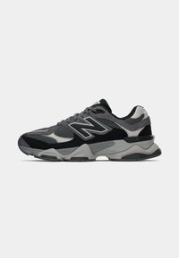 Chaussures de course pour hommes avec une tige en mesh et en suede dans des nuances de gris, présentant un design texturé, un col rembourré et une semelle épaisse.