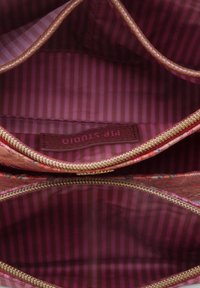 Textiel zakje met een gouden rits, voorzien van een bloemenpatroon in warme kleuren. Binnenkant gevoerd met roze en bordeaux gestreepte stof. Merkenlabel zichtbaar.