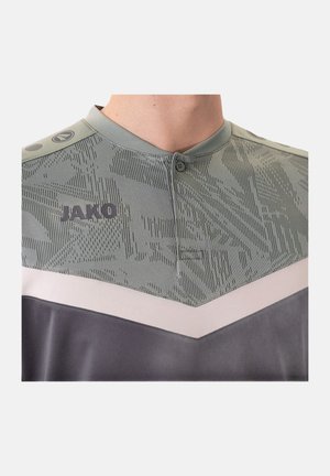 T-shirt à manches courtes de style henley en vert clair avec des accents gris foncé. Présente un motif texturé et un bouton au col. Logo "JAKO" visible.