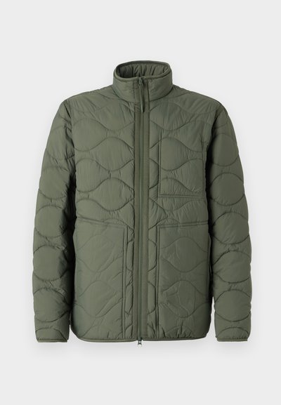Jachetă puffer verde măslin cu guler înalt, textură matlasată, închidere frontală cu fermoar și două buzunare mari, înclinate.