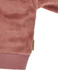 Pink fleece sweatshirt with a soft, textured finish, ribbed cuffs, and a small fabric label on the side.