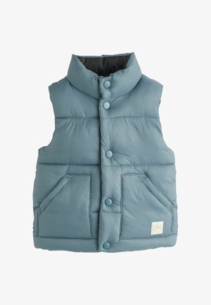 Veste bleu matelassée sans manches avec col montant, boutons-pression sur le devant, deux poches avant et une petite étiquette blanche sur la poche inférieure droite.